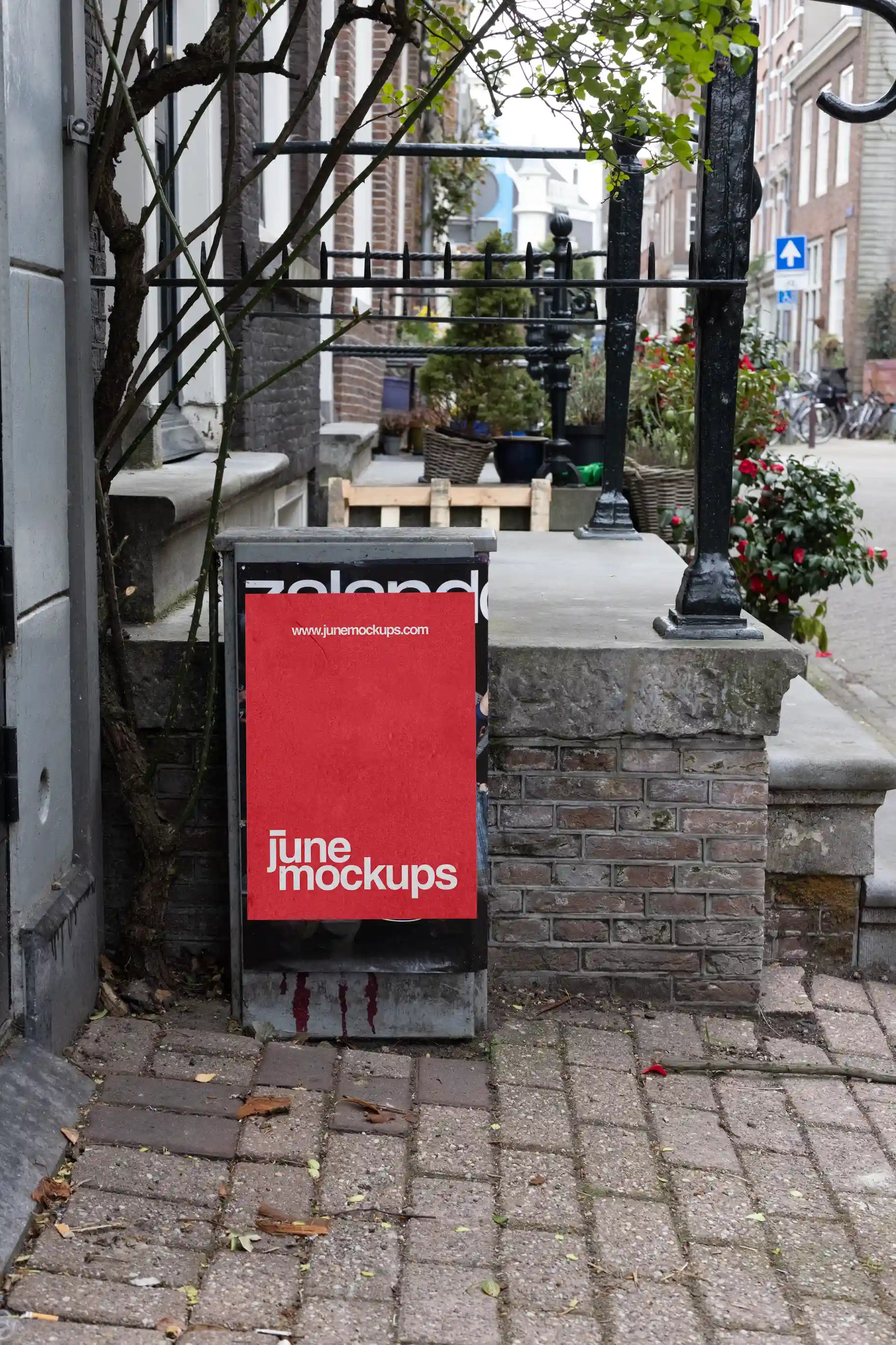 Amsterdam urban poster mockup with red textured design on small wall in quiet street.