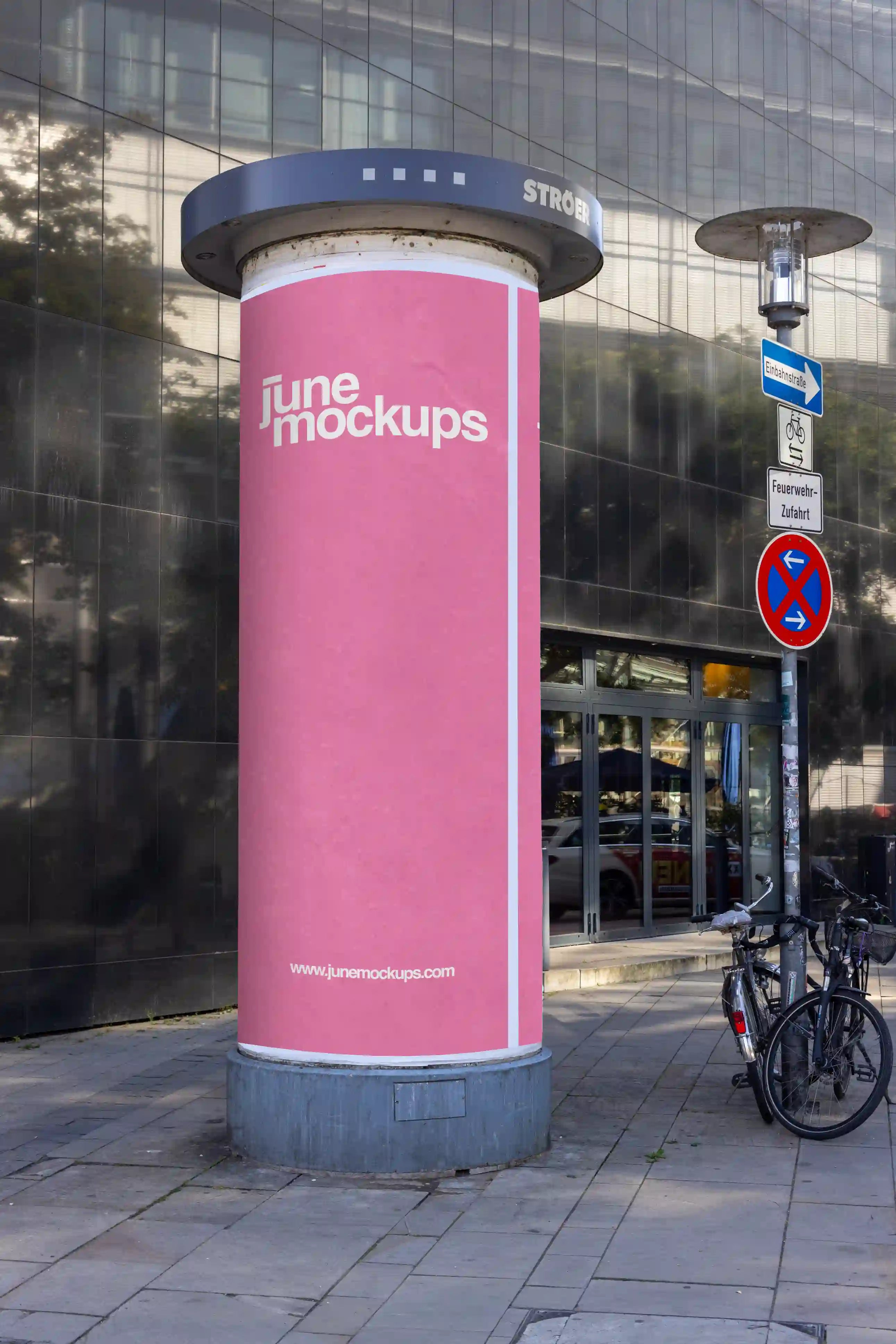High-quality mockup of a pink poster on an advertising column (Litfaßsäule) near Theater am Aegi in Hannover. Captures natural daylight reflections, realistic paper texture, and urban surroundings — perfect for showcasing cultural event or brand poster designs.