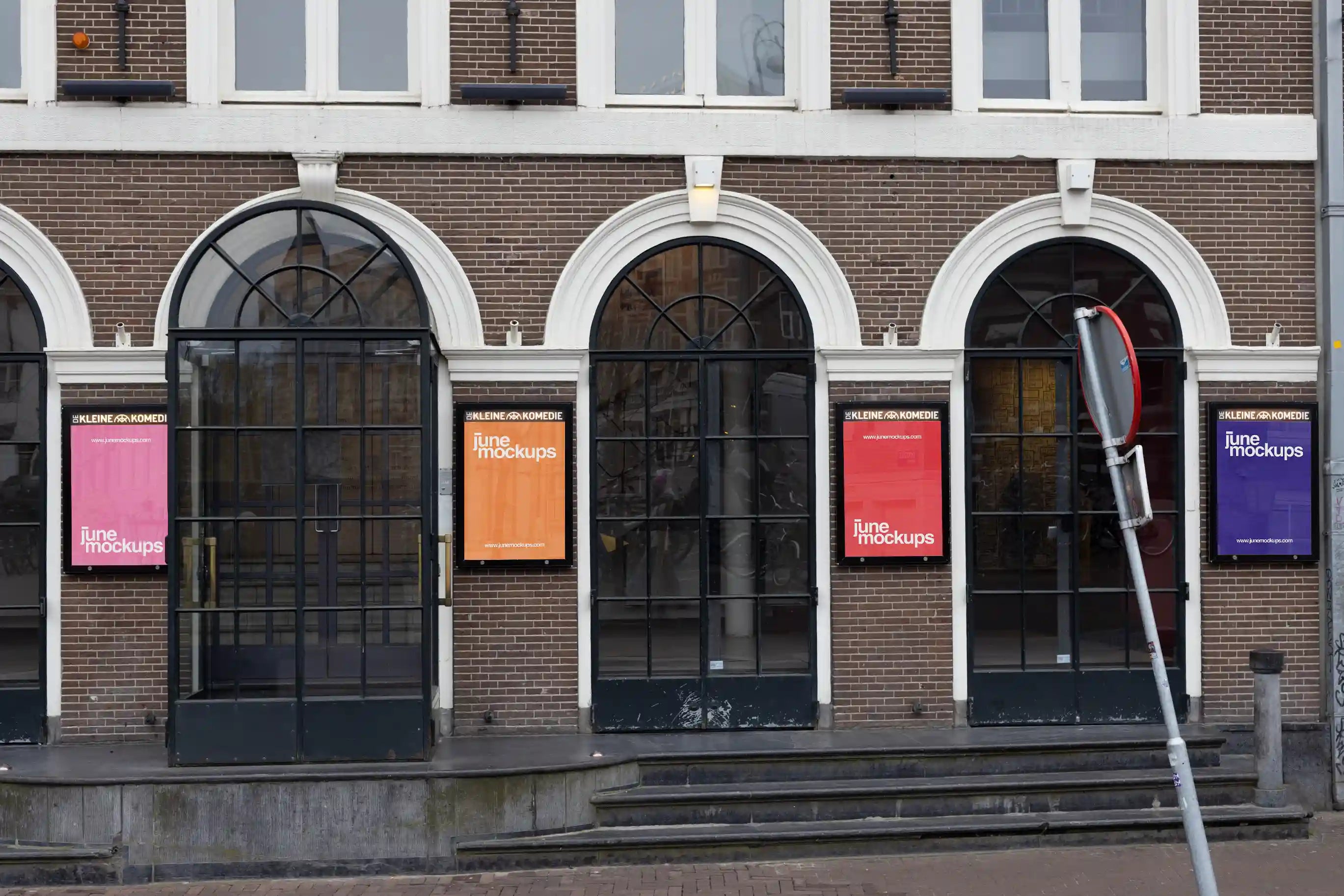 City light poster mockups at the entrance of De Kleine Komedie theater in Amsterdam, colorful posters under arched windows.