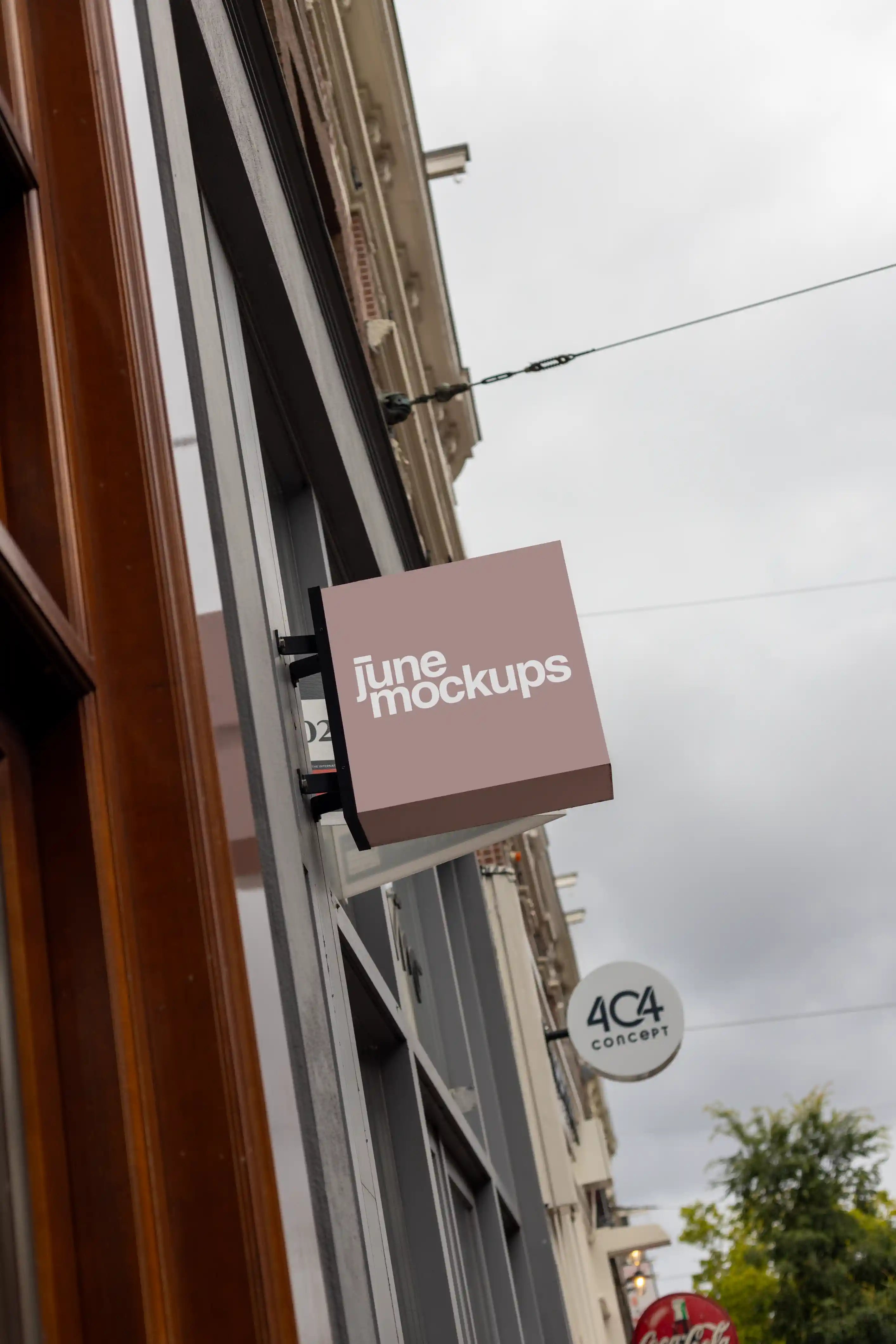 Square hanging store sign mockup in Amsterdam mounted on a modern urban shop facade, realistic wall mounted signage template in high resolution for branding, retail identity and exterior storefront presentation.