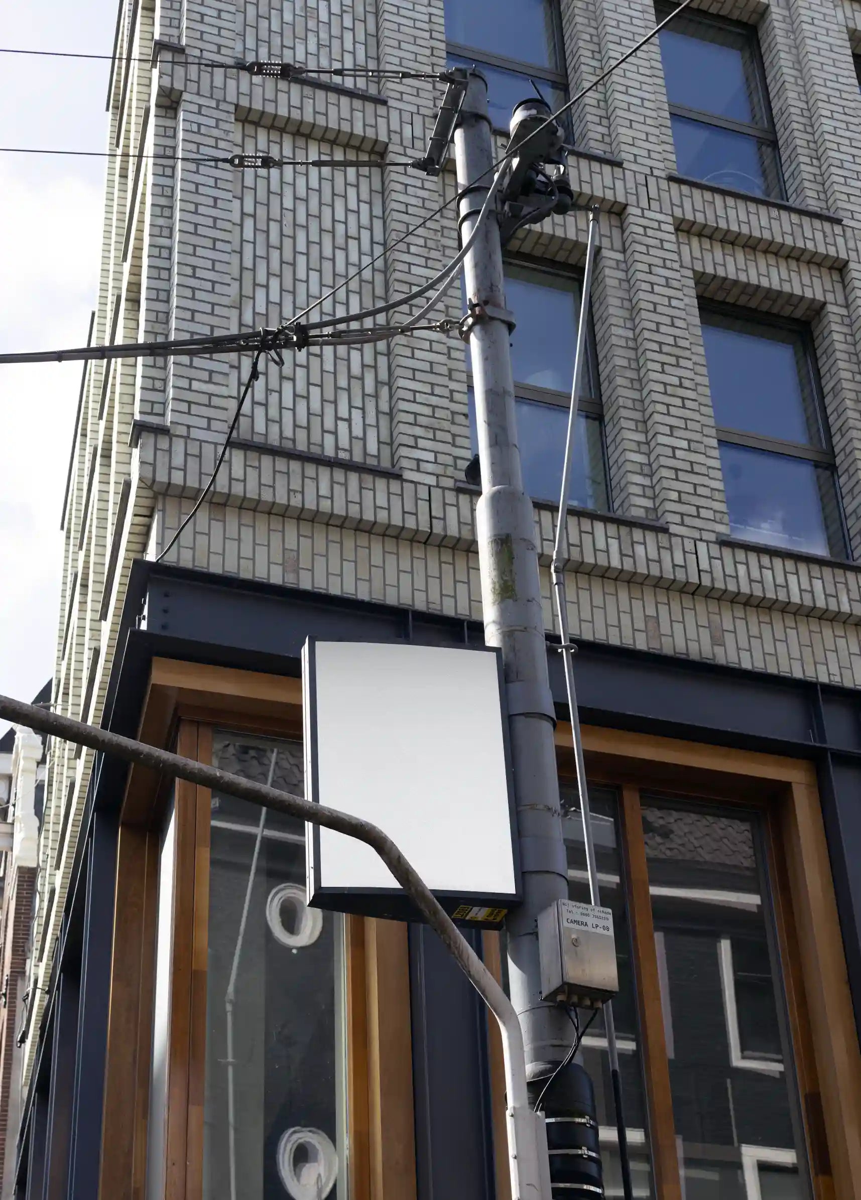 Amsterdam urban street mockup at Leidseplein with white vertical sign on street lamp