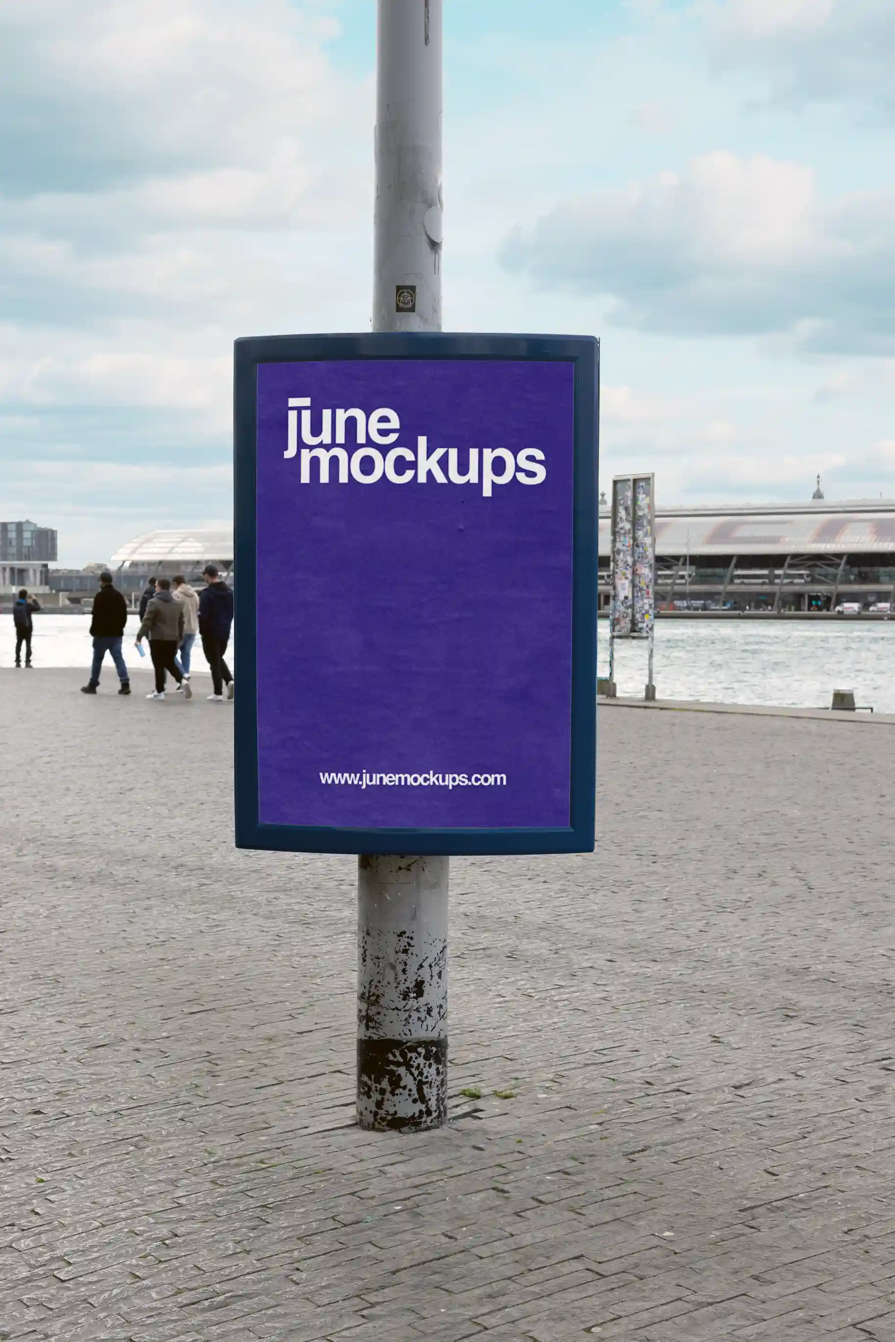 Poster mockup by the waterfront near Eye Filmmuseum and in front of Central Station in Amsterdam, with pedestrians in the background, great for outdoor marketing visuals.