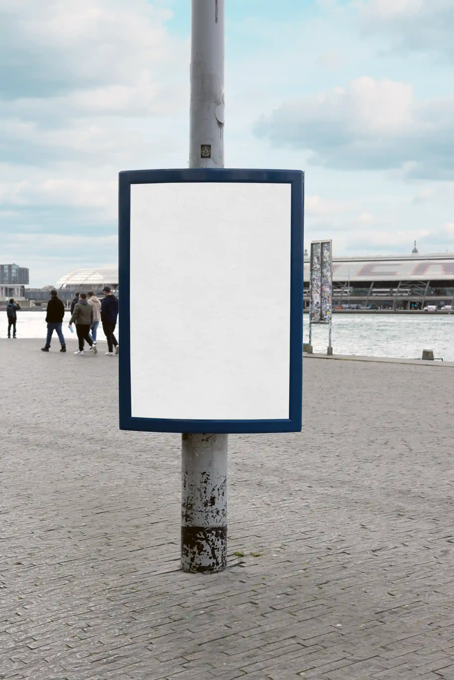 Poster mockup by the waterfront near Eye Filmmuseum in front of Central Station in Amsterdam, with pedestrians in the background, great for outdoor marketing visuals.