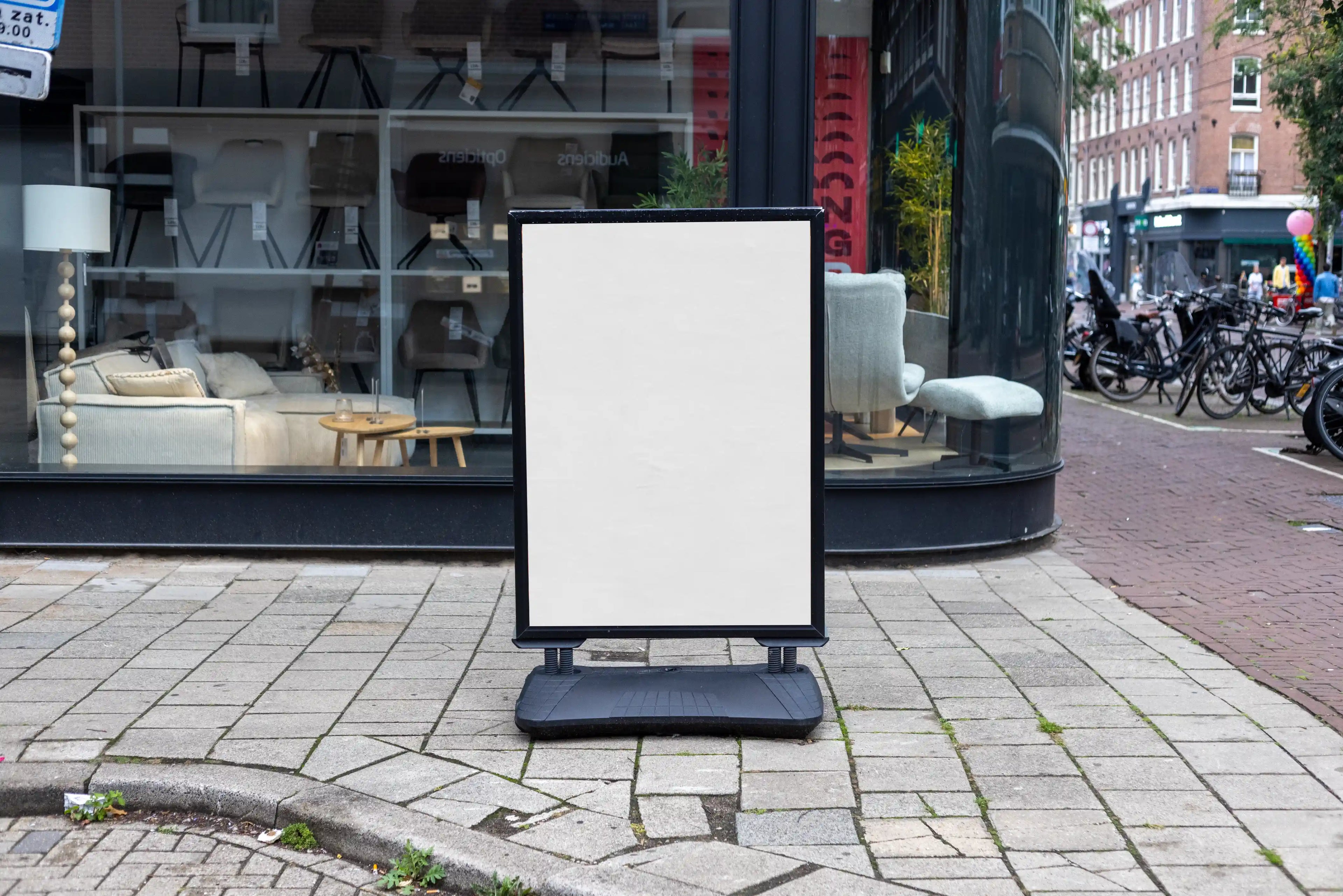 Realistic street poster board mockup in Amsterdam placed on urban sidewalk in front of modern shop window, high resolution PSD template ideal for branding and outdoor advertising design.