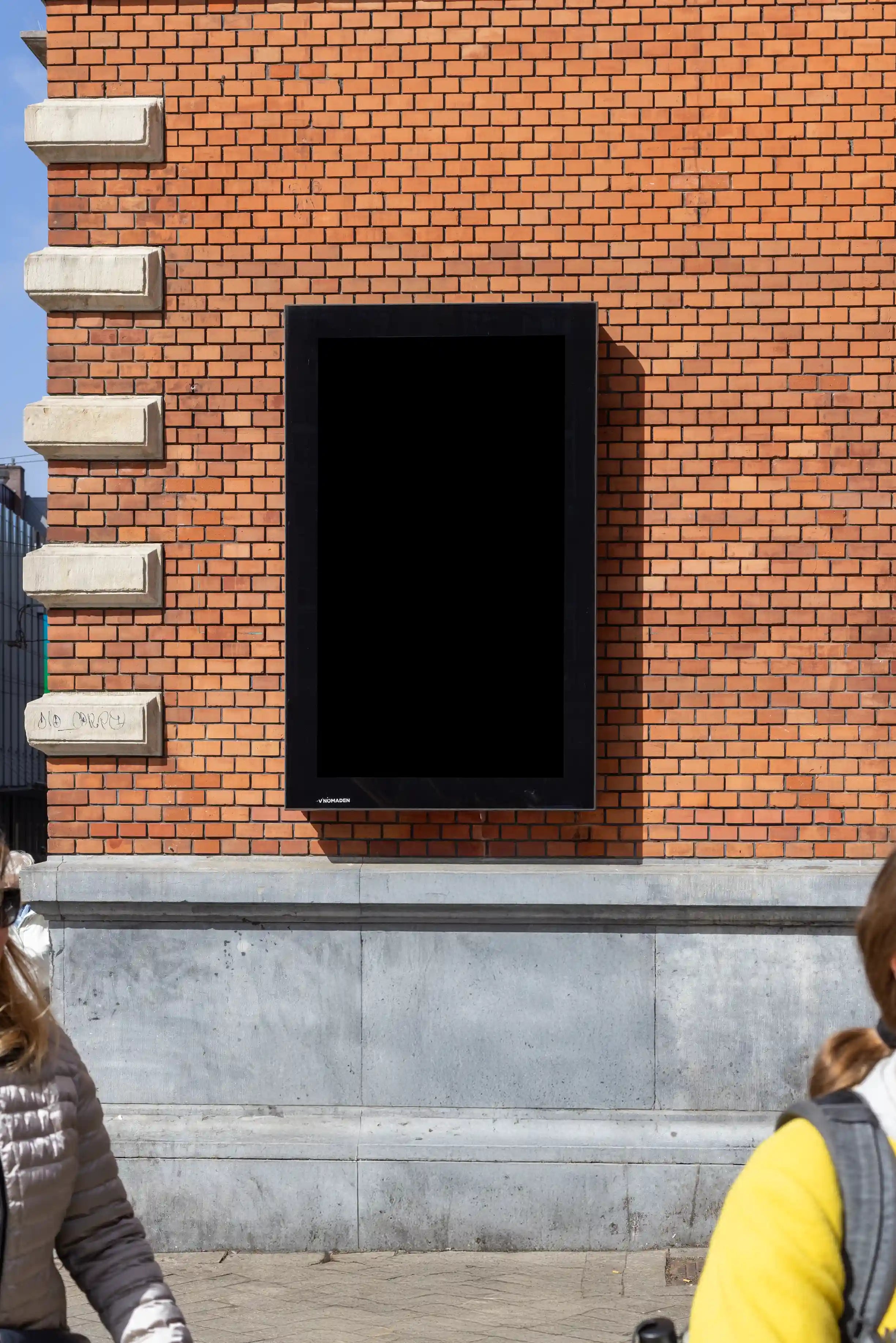 Amsterdam City Light Mockup mounted on red brick wall of Schouwburg Theater.