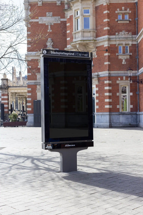 Amsterdam city light poster mockup in front of Schouwburg Theater with red brick facade.