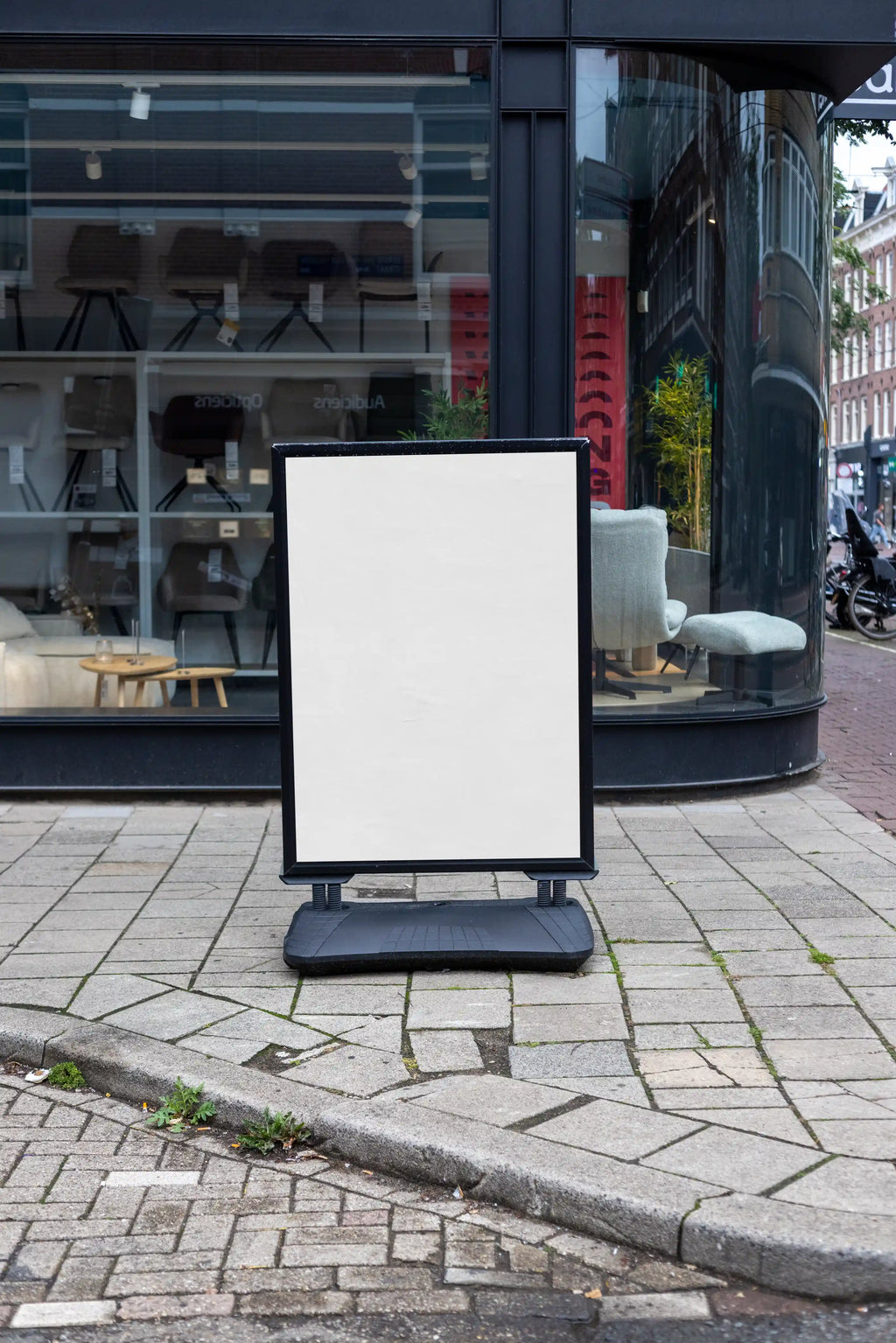 Blank background street poster board mockup in Amsterdam with realistic sidewalk and storefront setting, high resolution PSD template for outdoor advertising and branding presentations.