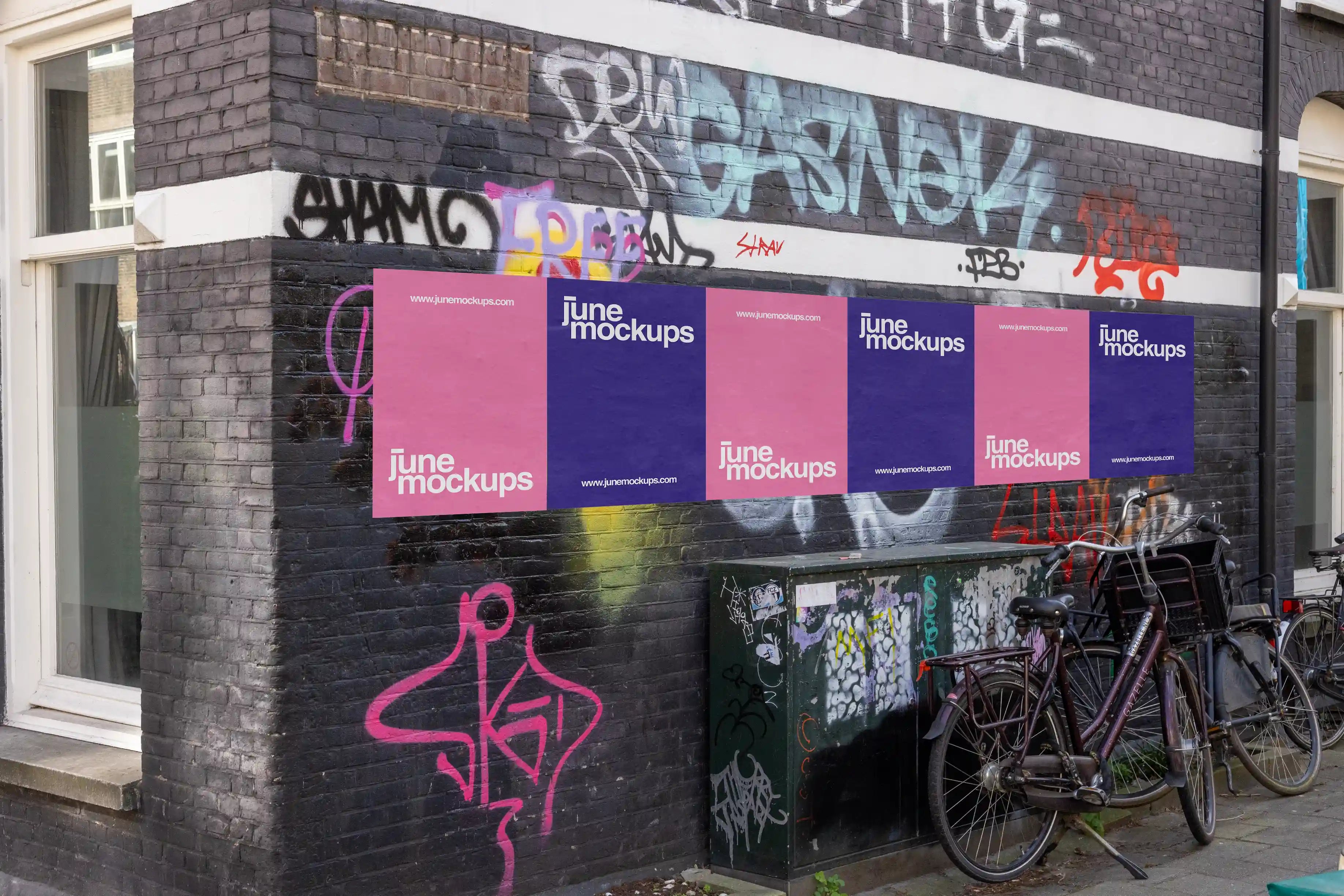 Amsterdam urban poster mockup on black brick graffiti-covered wall with bicycles.