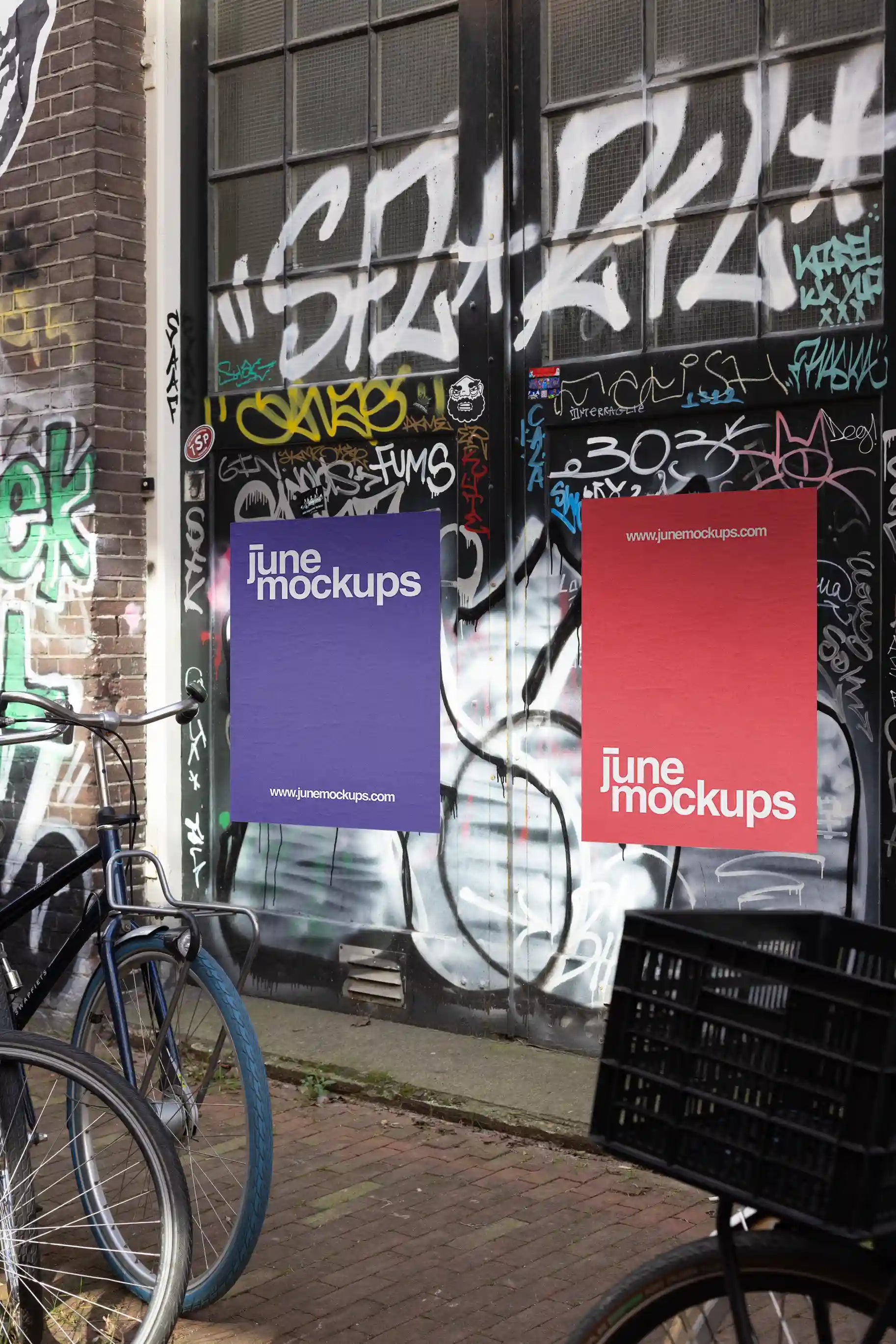 Amsterdam urban street mockup with two posters, red and purple, next to parked bicycles in front of a graffiti door.