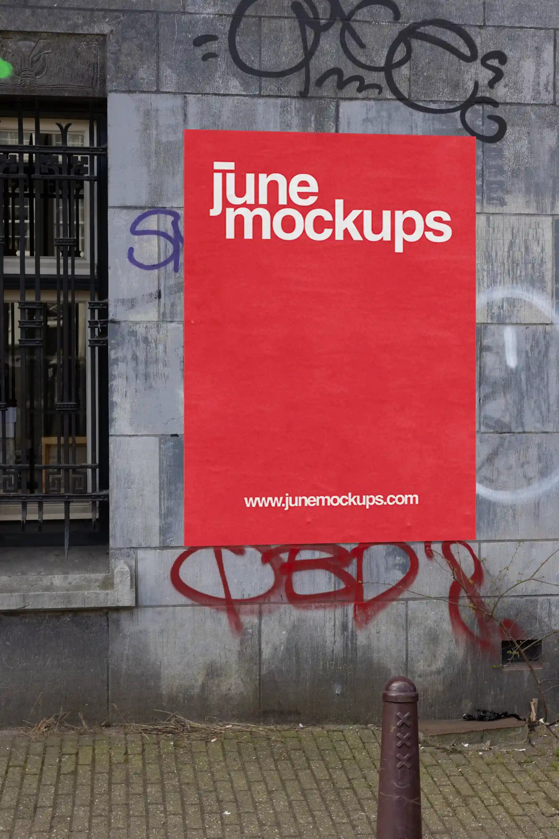 Amsterdam urban street mockup with single red poster on a grey stone wall with graffiti.