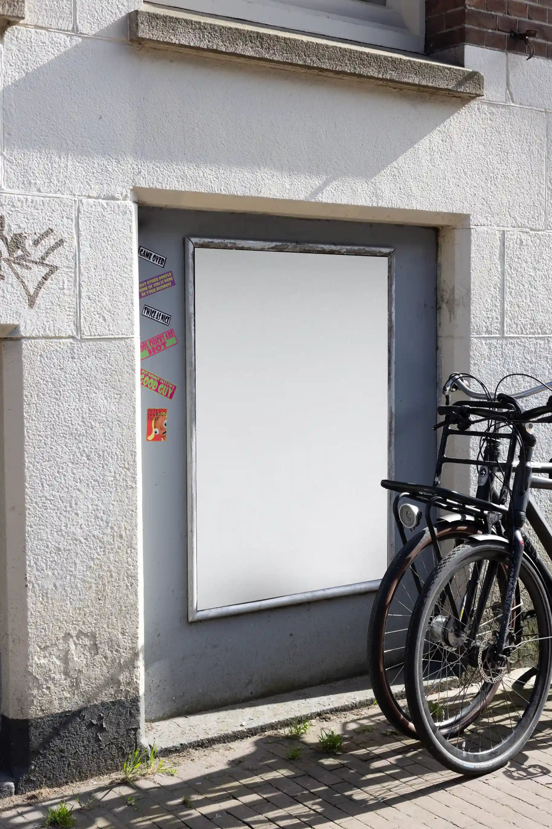 Amsterdam urban street mockup with bright white poster on white wall and black bicycle in front.
