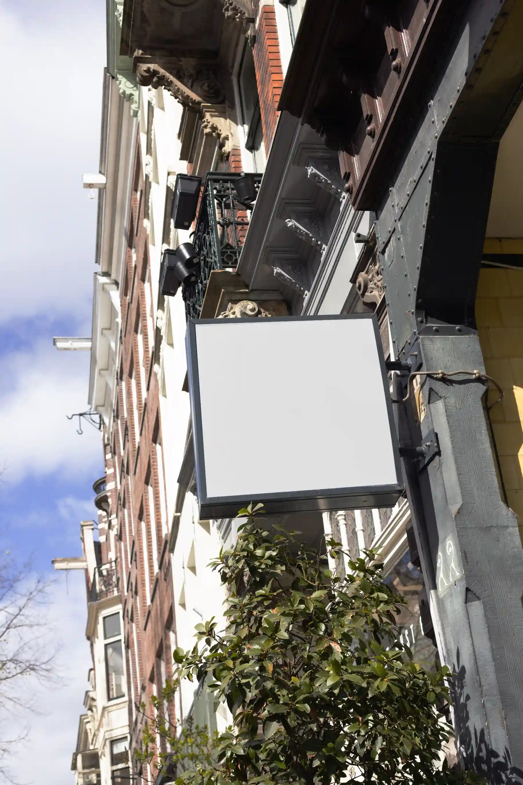 Amsterdam urban street logo mockup with vertical shop sign on traditional brick building facade.