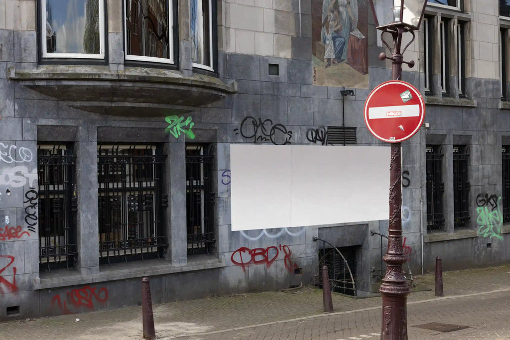 Amsterdam urban street mockup with three large posters on a graffiti-covered wall near the street.