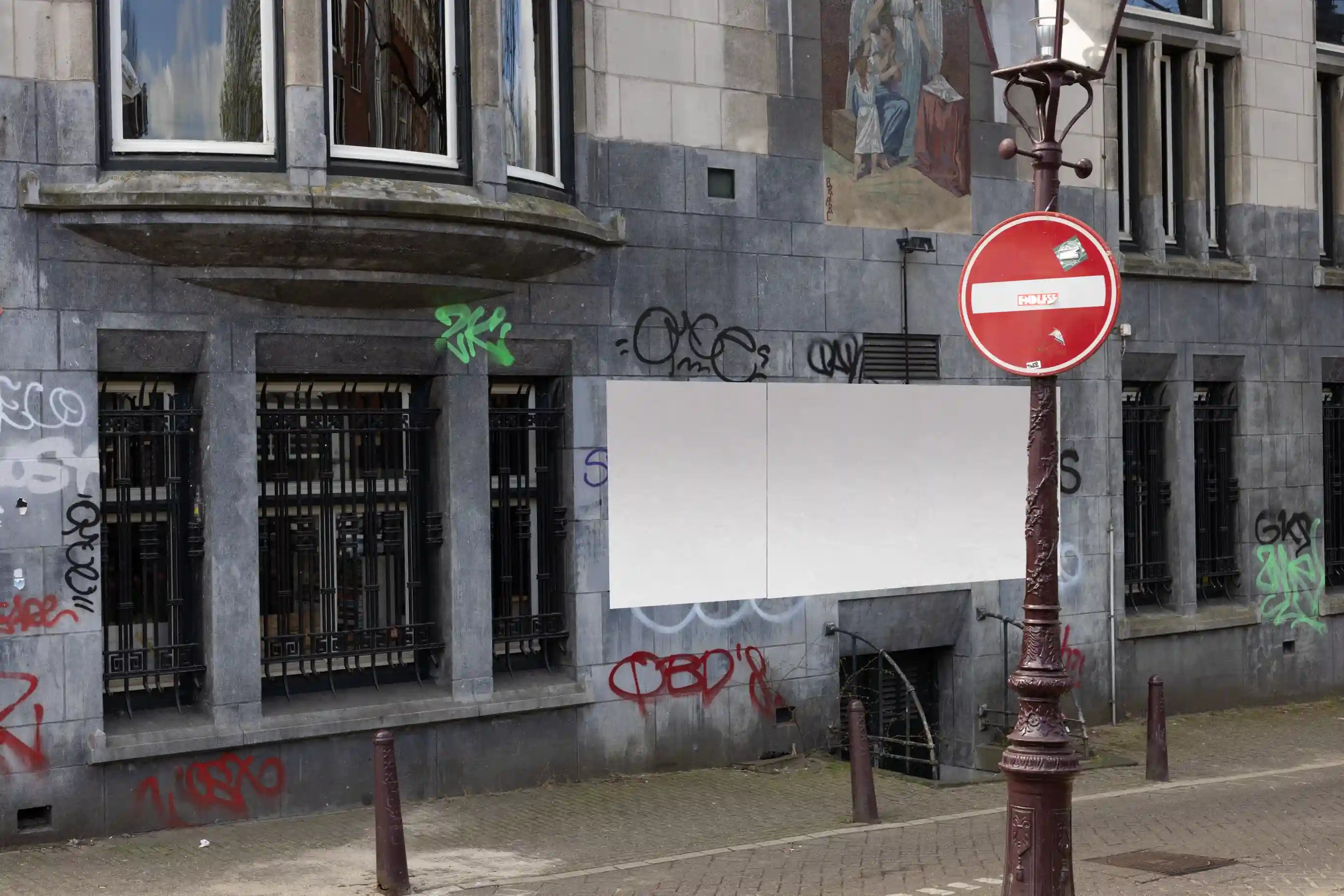 Amsterdam urban street mockup with three large posters on a graffiti-covered wall near the street.