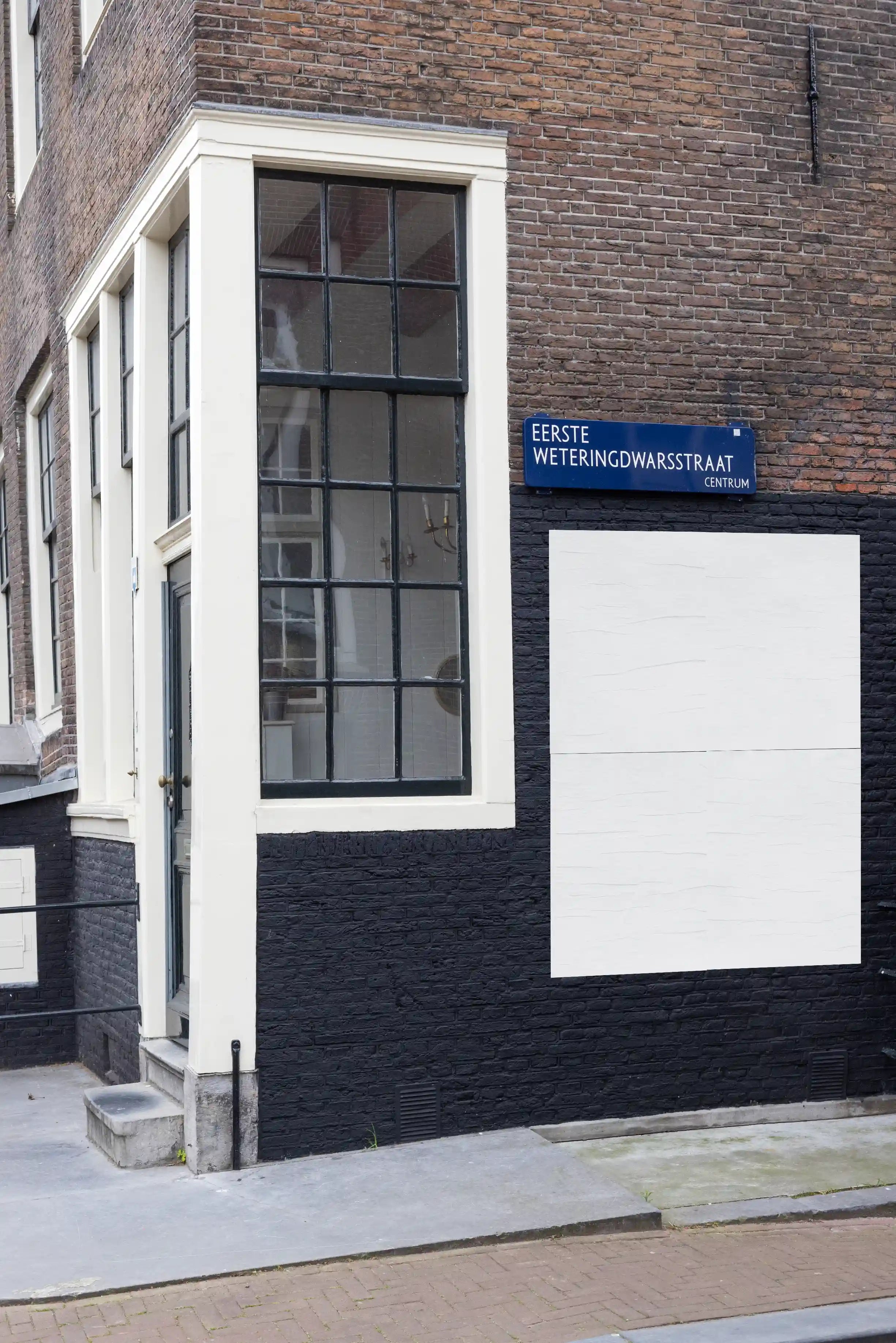 Urban street poster mockup in Amsterdam on the corner of Eerste Weteringdwarsstraat with classic brick facade and large window.
