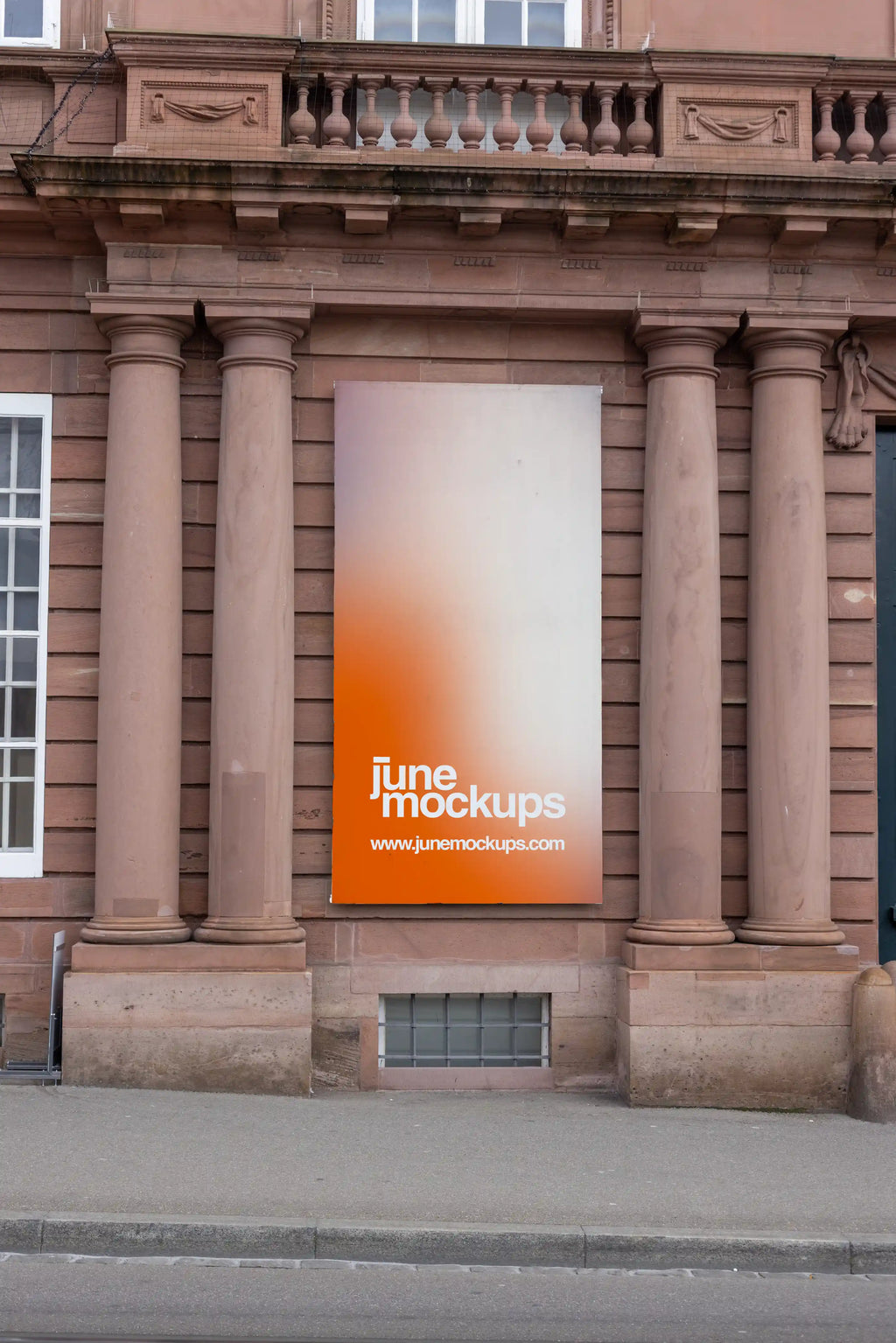 Vertical 1:2 banner mockup on the facade of the Historisches Museum Basel, Haus zum Kirschgarten. The large orange and white banner hangs between historic stone columns on a reddish sandstone building, with sidewalk and street curb visible below.