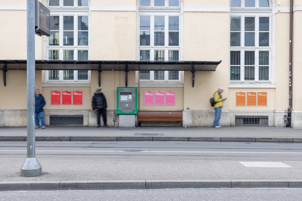 Nine small DIN poster mockups displayed in groups of three along a tram stop wall in Basel. The scene shows a public transport stop with a bench, ticket machine, blurred pedestrians, street tracks and a light building facade in the background.