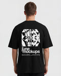 Realistic black streetwear t-shirt mockup showing a male model from the back with a large back print design, oversized fit, clean studio background and natural fabric folds, perfect for apparel branding, merch collections, music merchandise, fashion campaigns and streetwear clothing presentations.