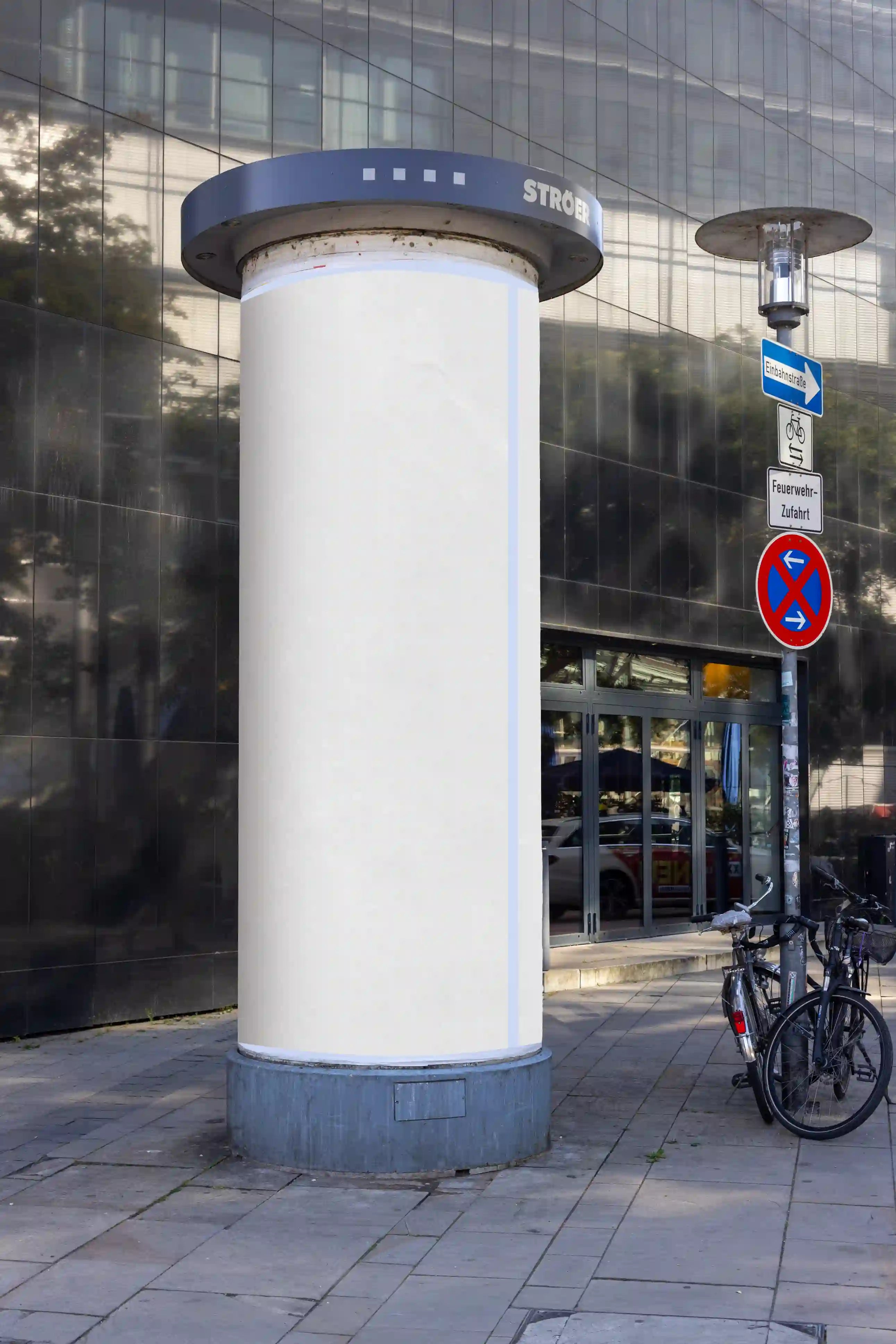 Blank advertising column mockup located at Aegidientorplatz in Hannover, near Theater am Aegi. Realistic urban street scene with clean paper texture and natural lighting. Ideal for professional outdoor poster presentations.