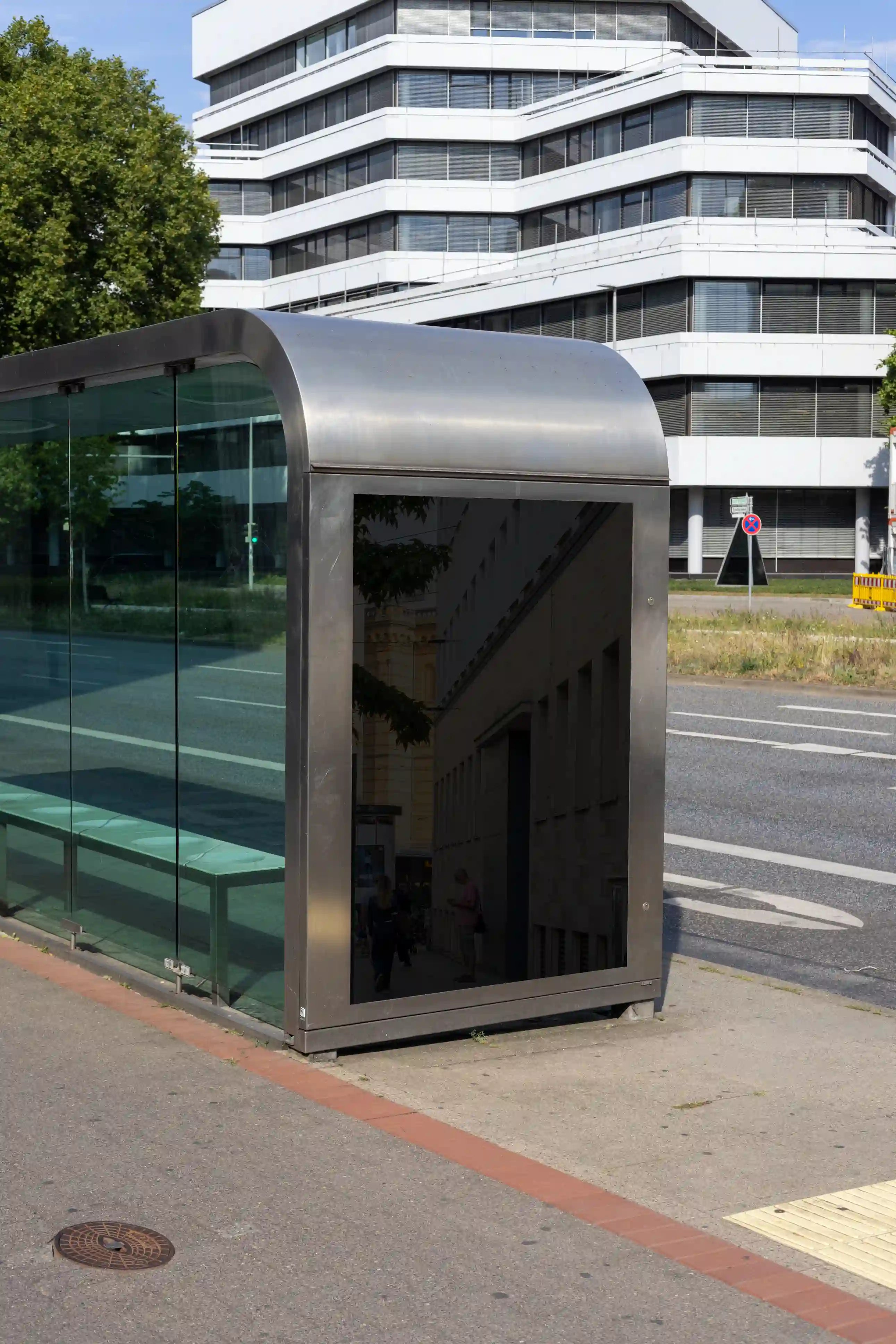 Blank city light mockup at a bus shelter in Hanover’s Aegidientorplatz. Clean composition, architectural reflections, and balanced lighting ideal for showcasing transport, fashion, or public campaign posters.