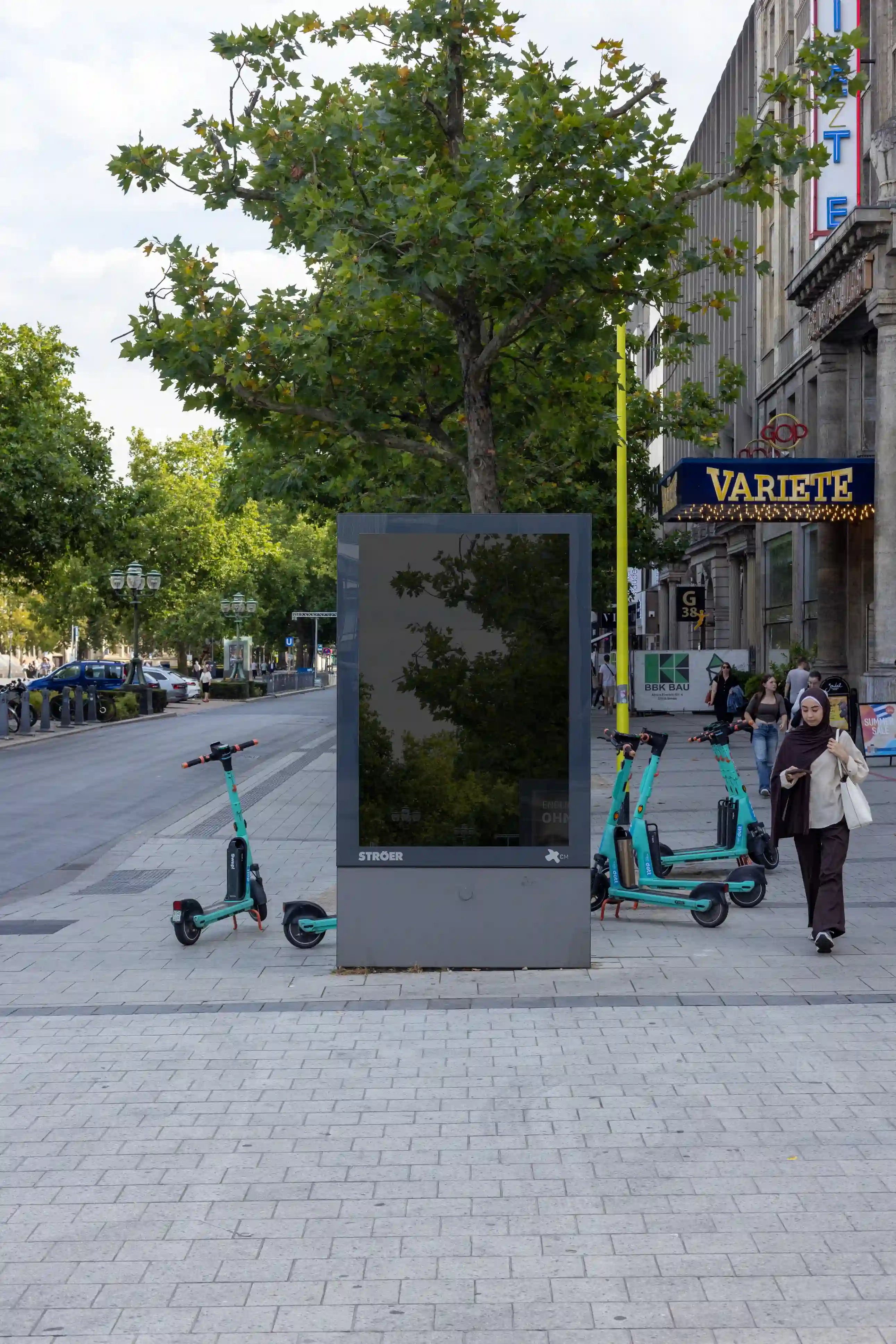 Blank city light advertising mockup in Hanover city center near the GOP Varieté and Opernhaus. Features realistic reflections, natural daylight, and clean glass surface for presenting poster or campaign designs.