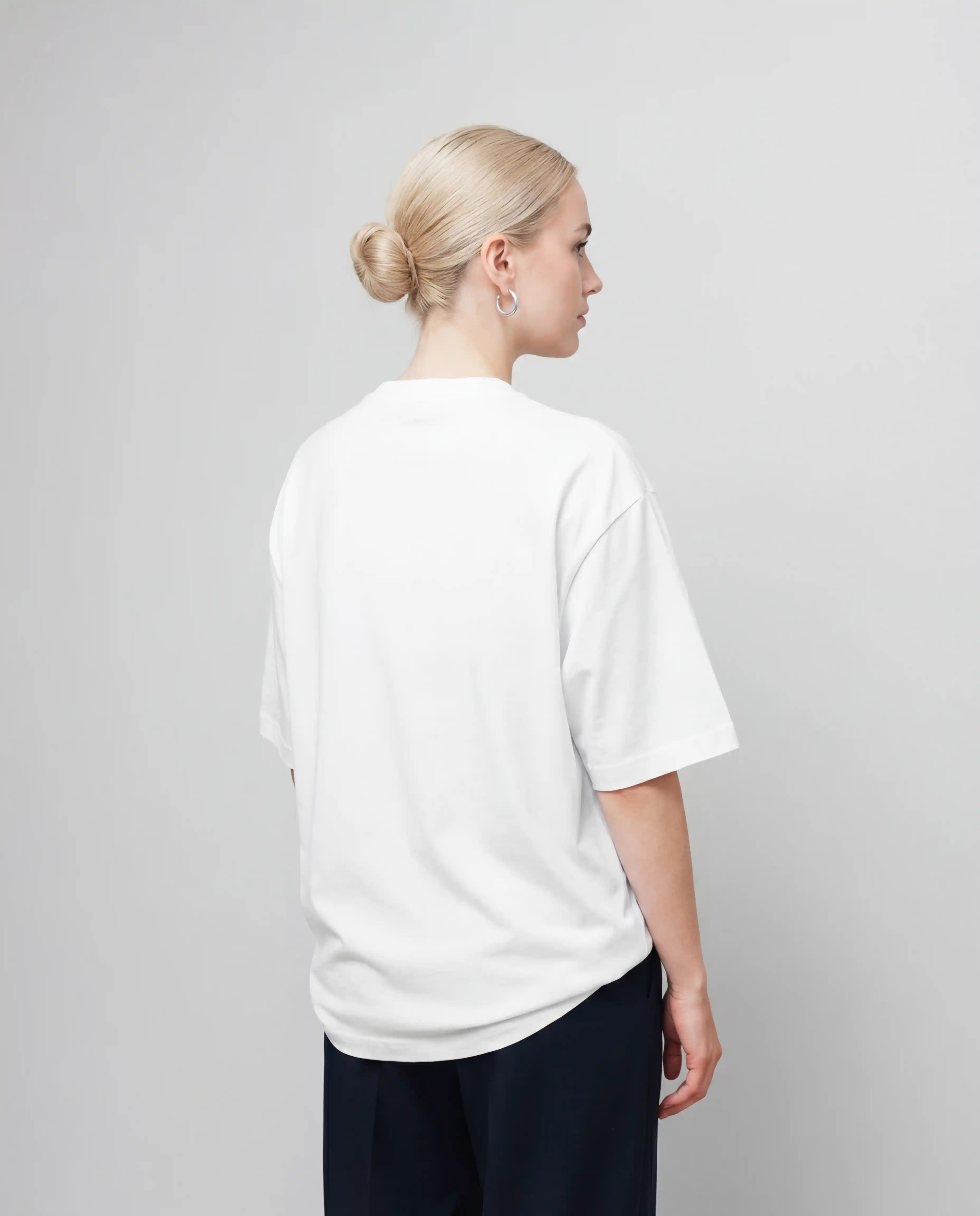 Female white oversized t-shirt mockup from the back with blank shirt surface, clean studio lighting and realistic fabric texture, ideal for back print designs, fashion brands, apparel mockups and streetwear product visuals.