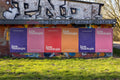Vivid outdoor poster mockup featuring multiple colorful posters arranged on an urban wall with natural light and realistic paper texture. Great for advertising, branding, or campaign visuals in modern city settings.