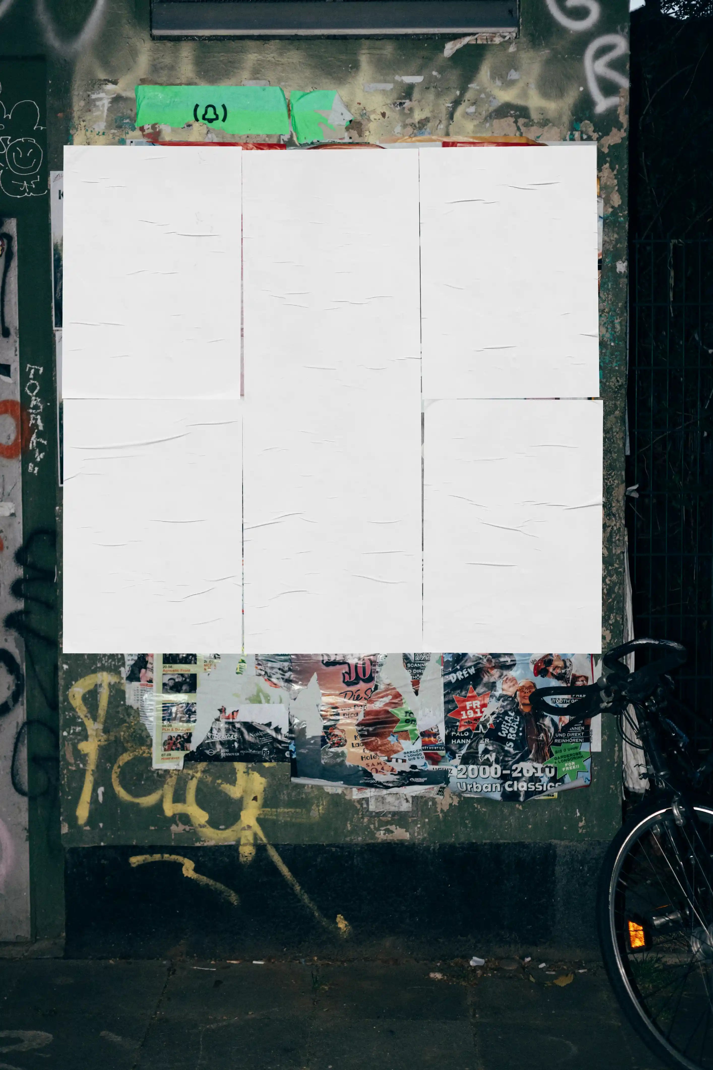 Urban poster mockup featuring a blank poster grid on a textured street wall with layered paper details, perfect for realistic outdoor advertising and branding presentations.