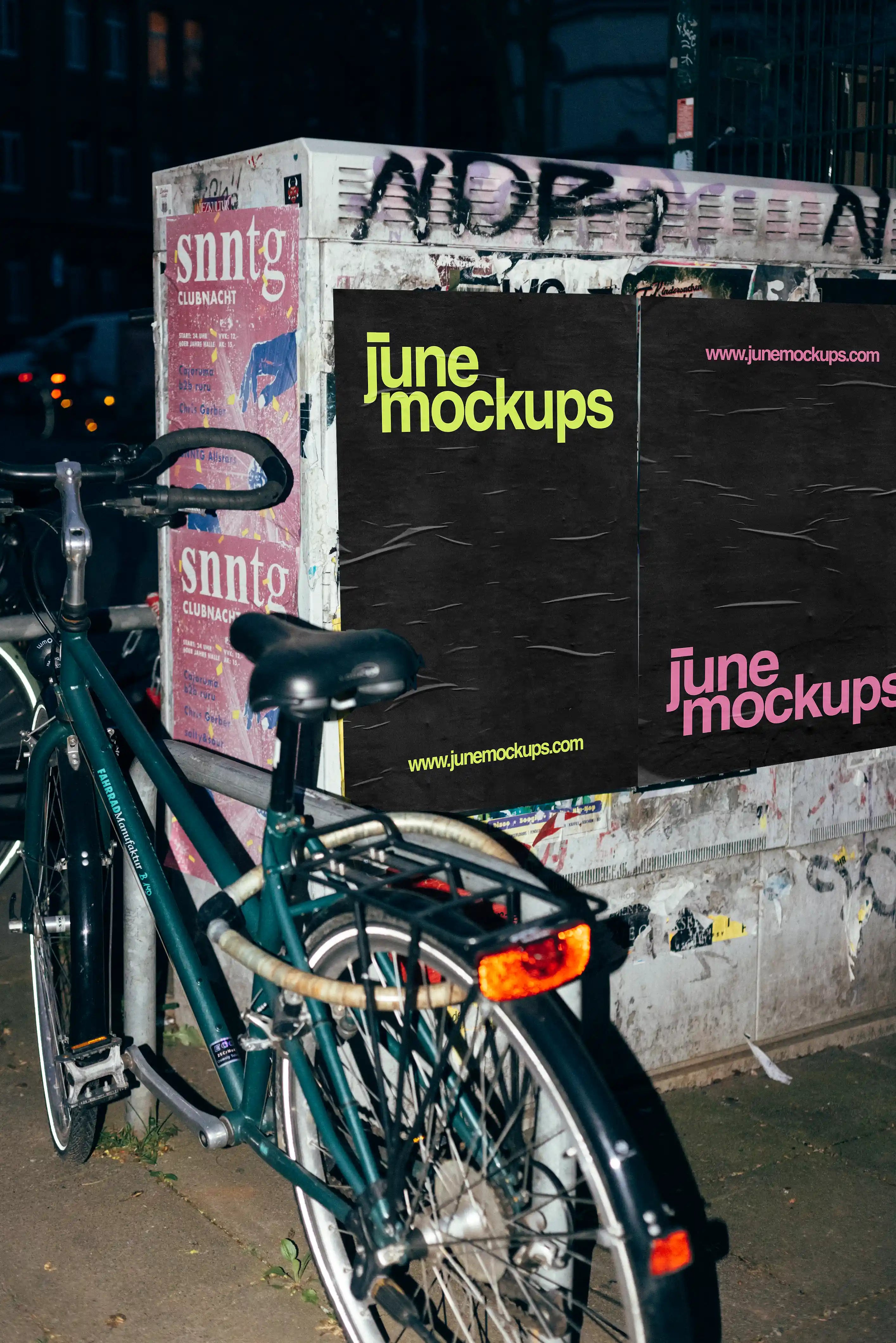 Urban poster mockup at night featuring street posters on a grunge wall next to a bicycle, capturing a realistic city advertising scene with authentic lighting and textures.